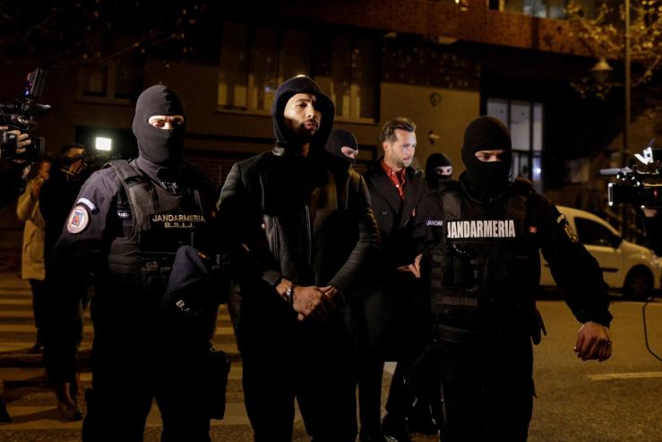 Andrew Tate and Tristan Tate escorted by police officers in Bucharest after being detained for 24 hours on Dec. 29, 2022