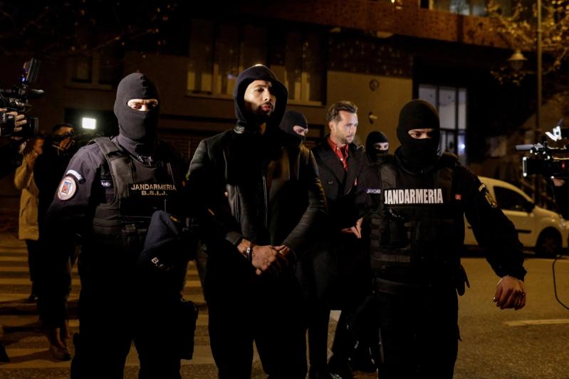 Andrew Tate and Tristan Tate escorted by police officers in Bucharest after being detained for 24 hours on Dec. 29, 2022
