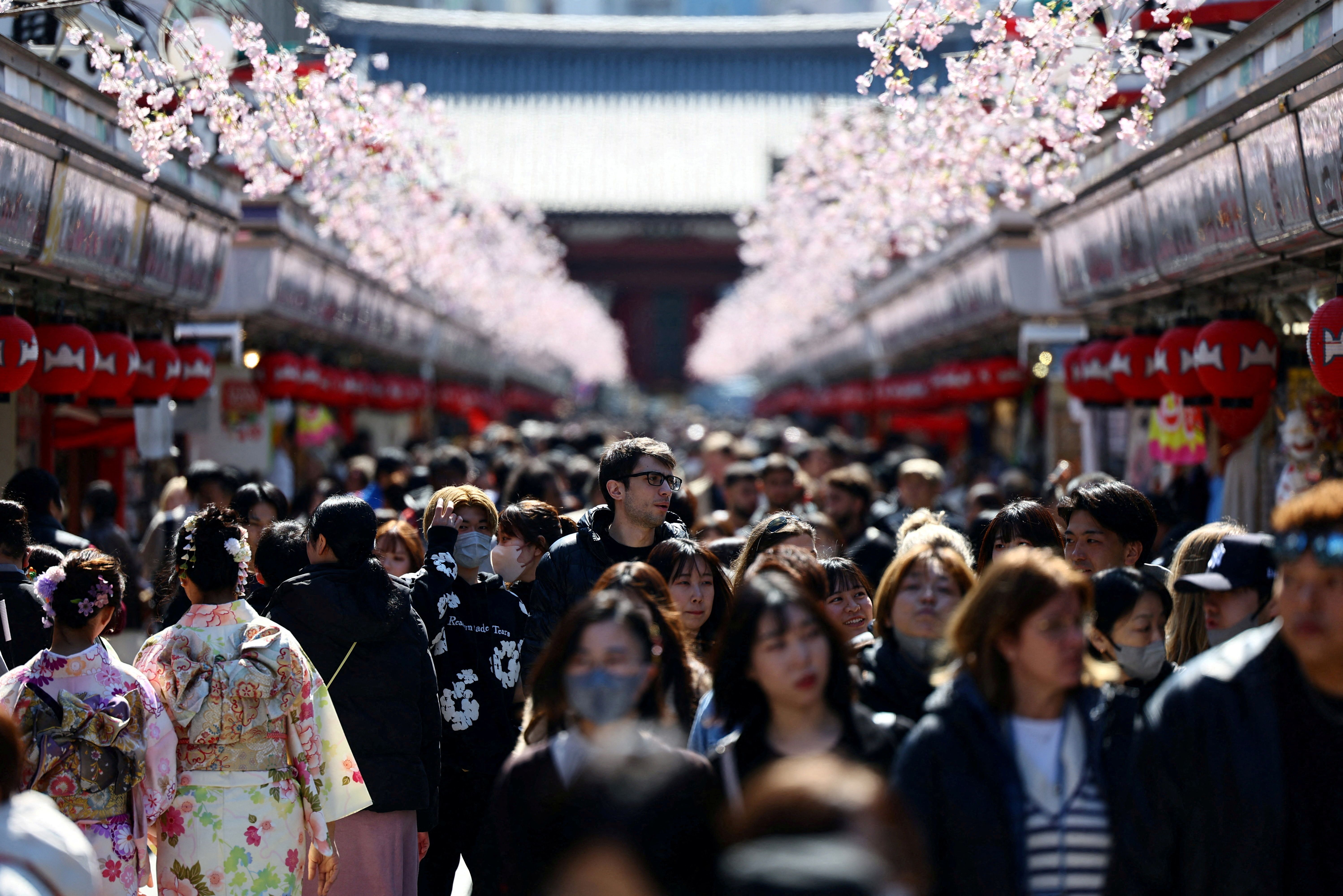 Visitors walk along Nakamise-dori street in Tokyo.