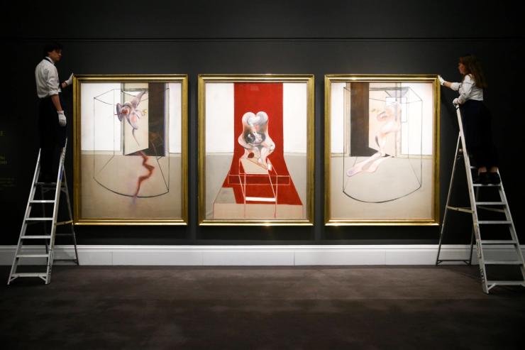 Gallery assistants pose for photographers during the photocall for ‘Triptych Inspired by the Oresteia of Aeschylus’ by British painter Francis Bacon.