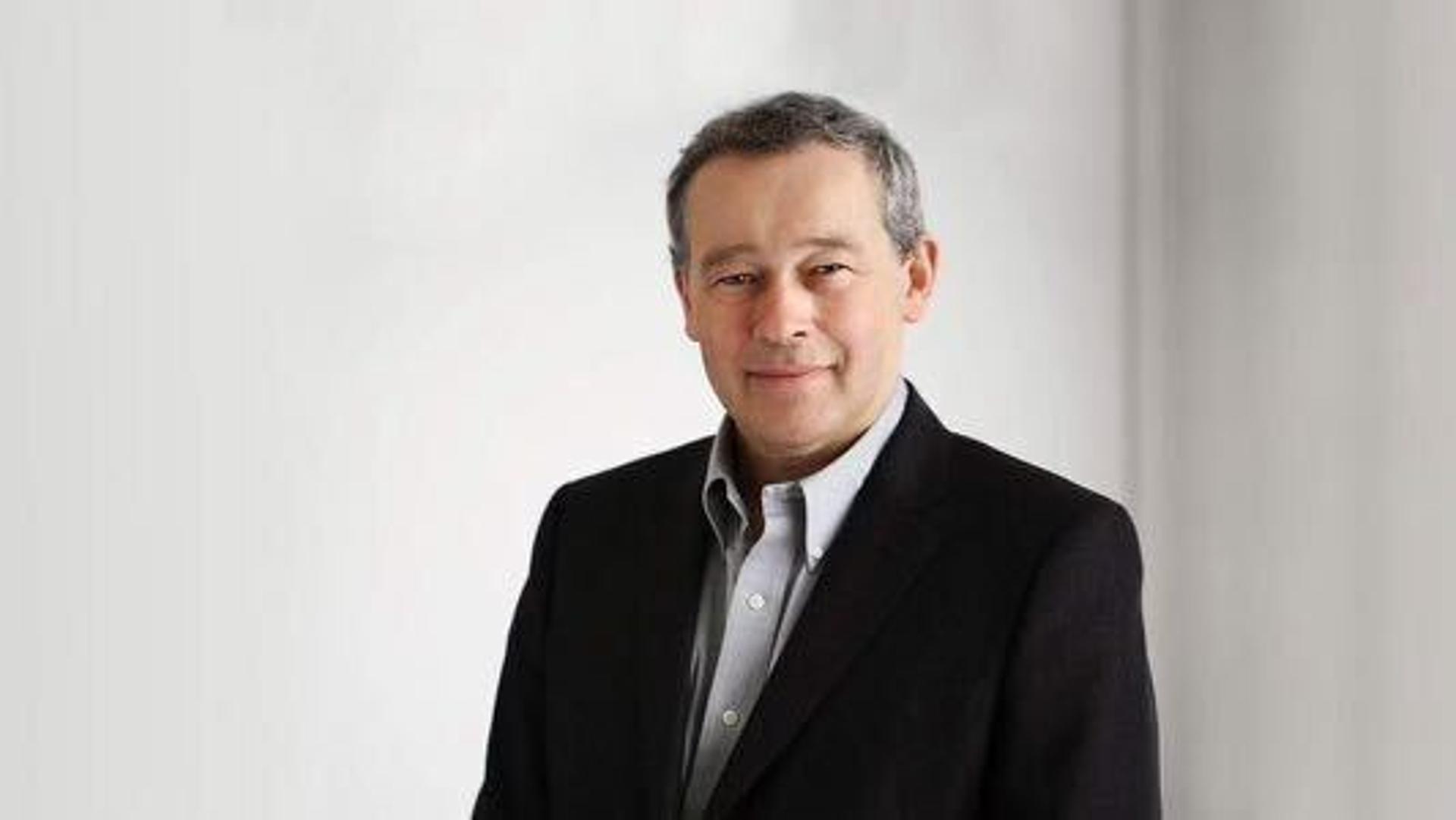 Headshot of Peter Rawlinson, a white, clean-shaved man with short grey hair wearing a dark suit and shirt