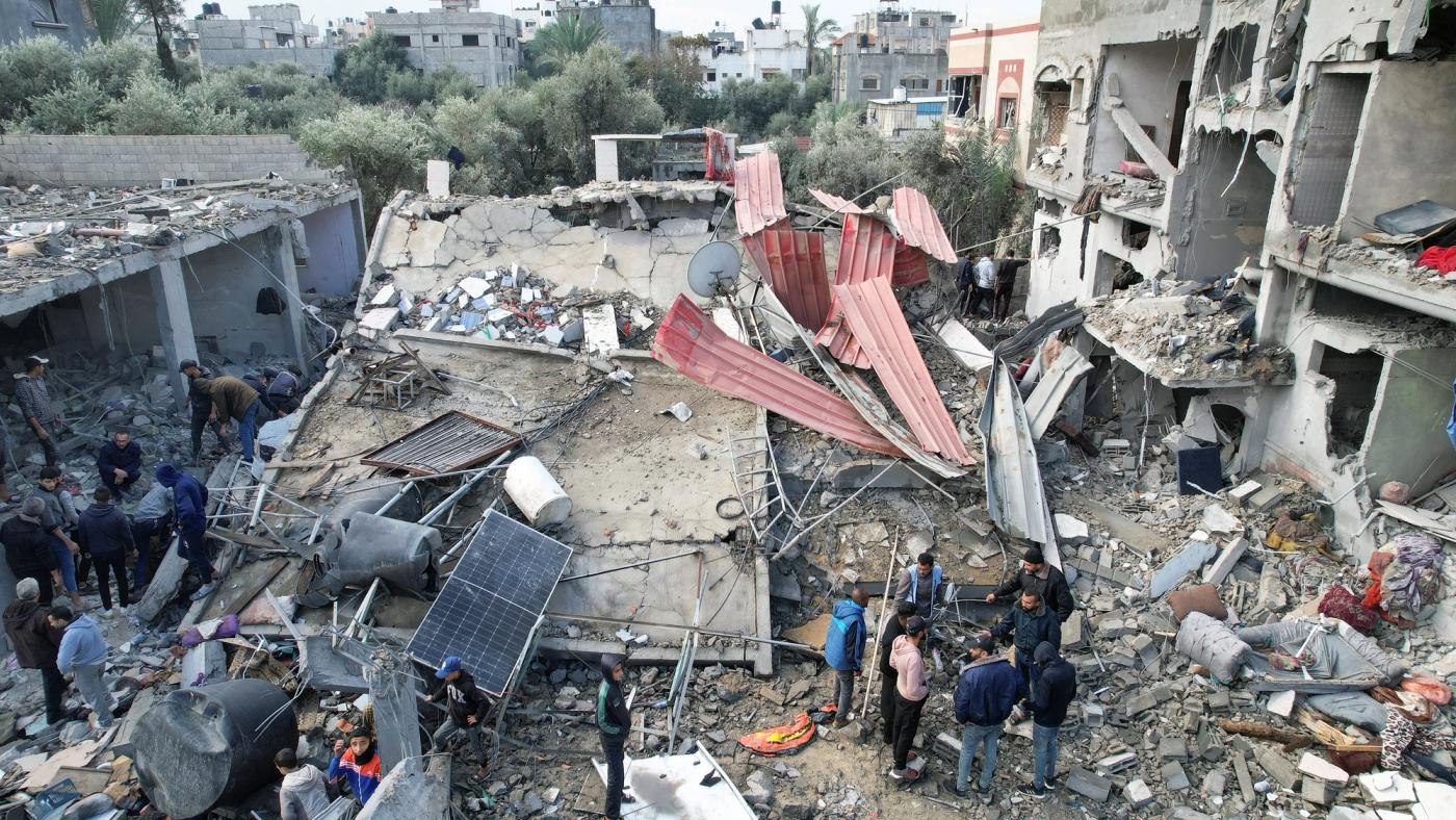 Palestinians gather at the site of Israeli strikes on houses, amid the ongoing conflict between Israel and the Palestinian Islamist group Hamas, at the Maghazi camp in the central Gaza Strip, December 25, 2023. 