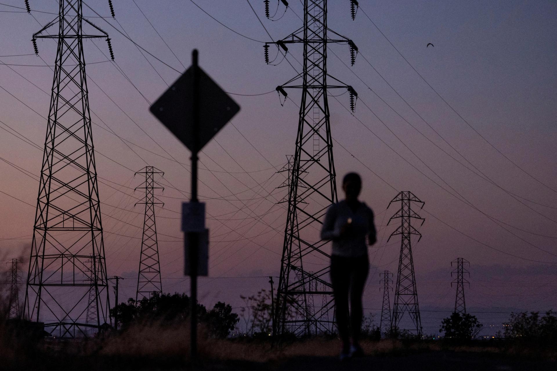 A woman jogs by power lines.