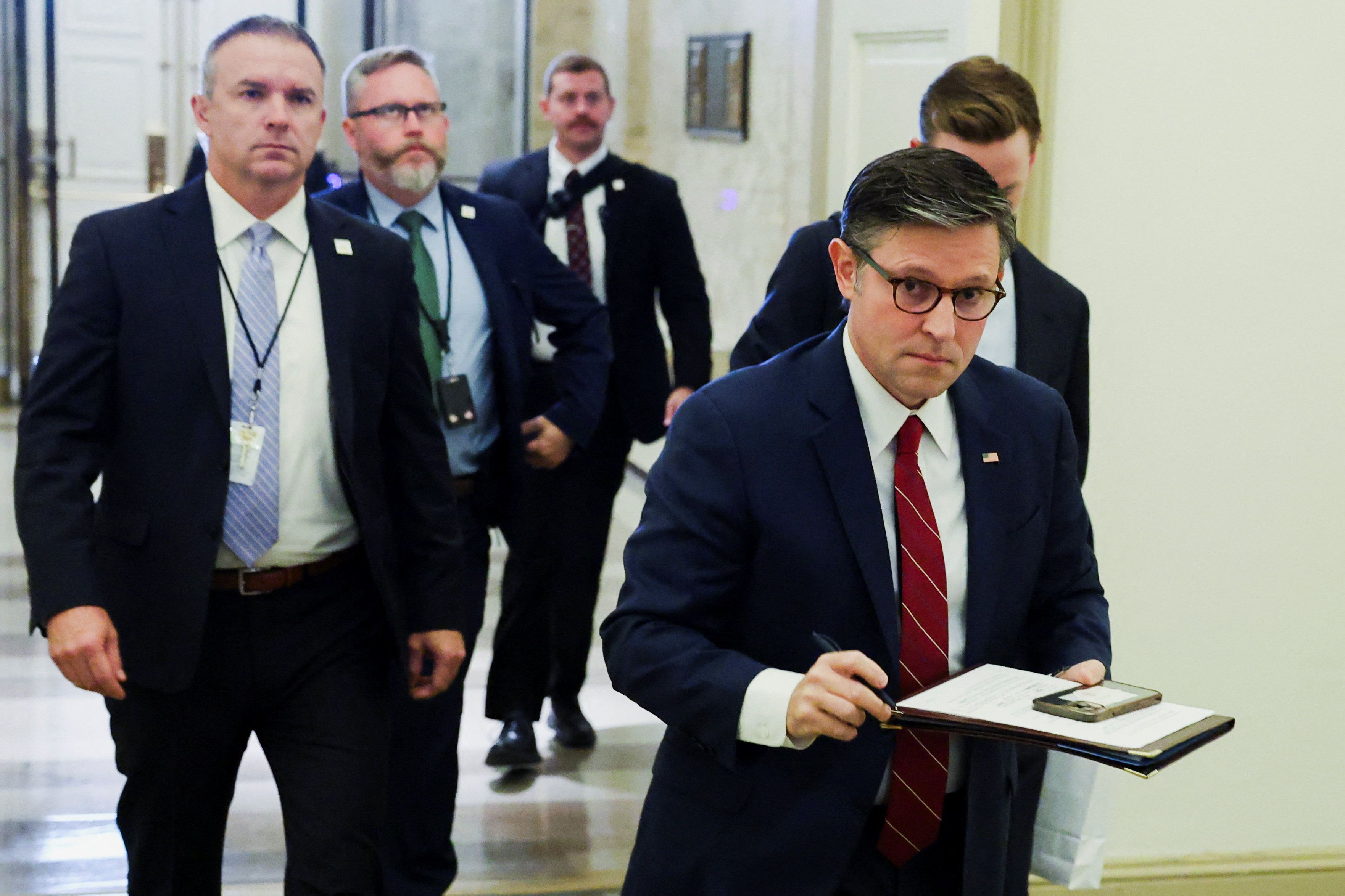 House Speaker Mike Johnson arrives at the US Capitol with his security detail. 