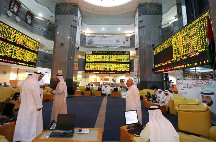 Investors monitor screens displaying stock information at the Abu Dhabi Securities Exchange.