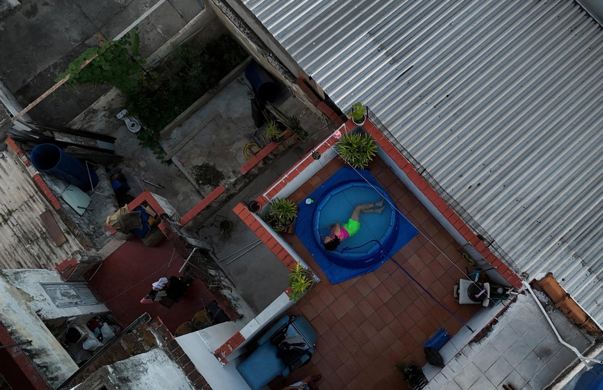 A drone view shows Neysi Fuentes, 50, lying in a plastic pool at her home to cool down due to the hot weather in Rio de Janeiro, Brazil February 5, 2025.