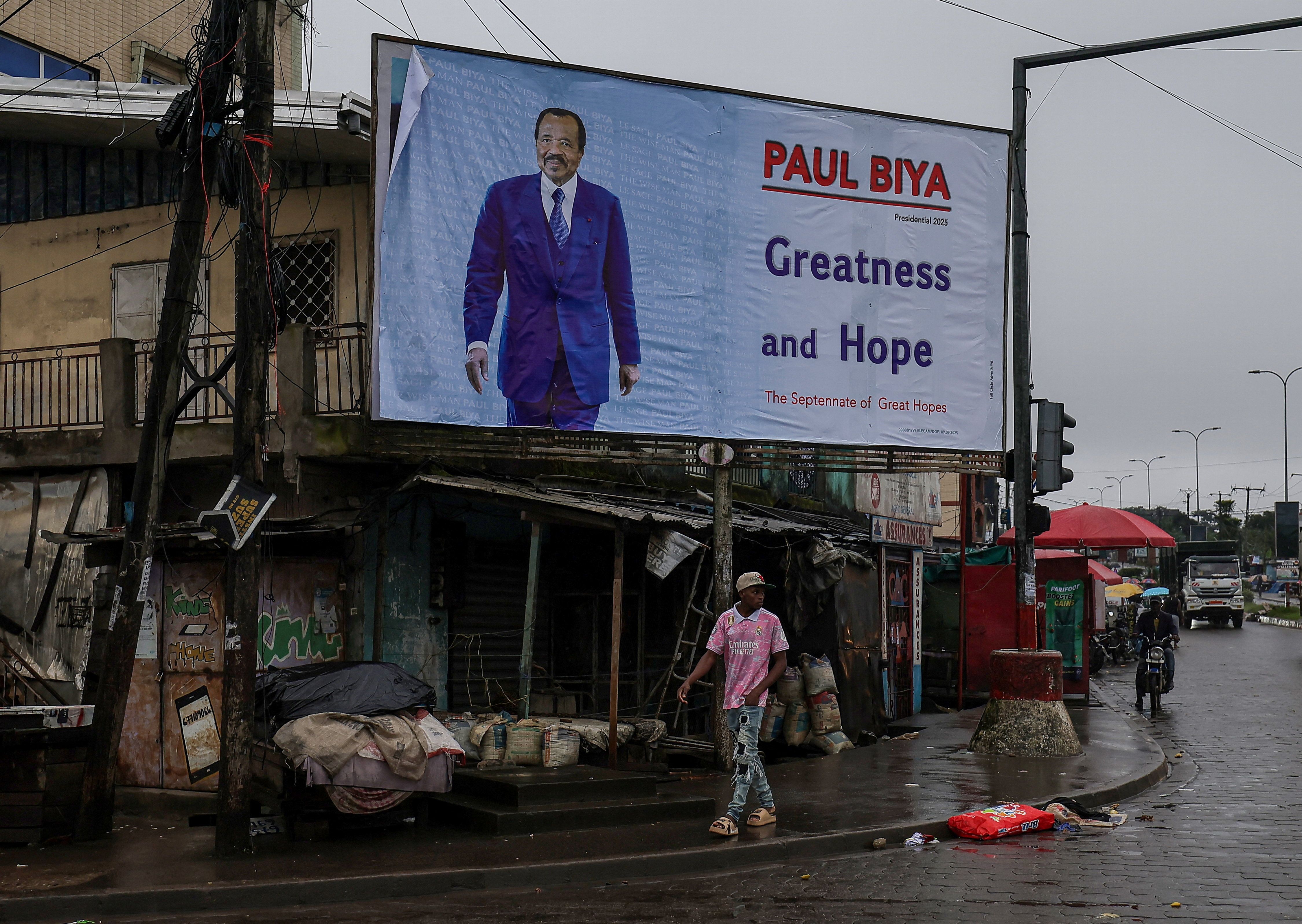 A man walks past an election campaign billboard for Cameroon’s 92-year-old President Paul Biya.