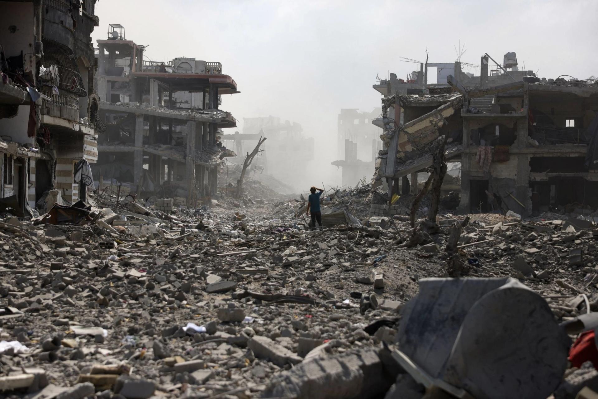 A Palestinian youth stands on a street strewn with rubble following an explosion in the Saftawi neighbourhood, west of Jabalia in the northern Gaza Strip.