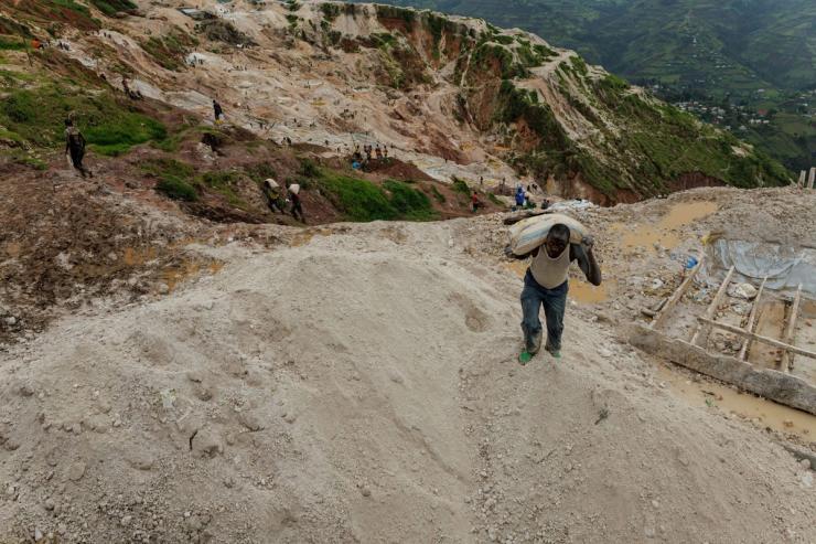 A laborer carries a sack of ore at the Rubaya coltan mine in eastern DR Congo.
