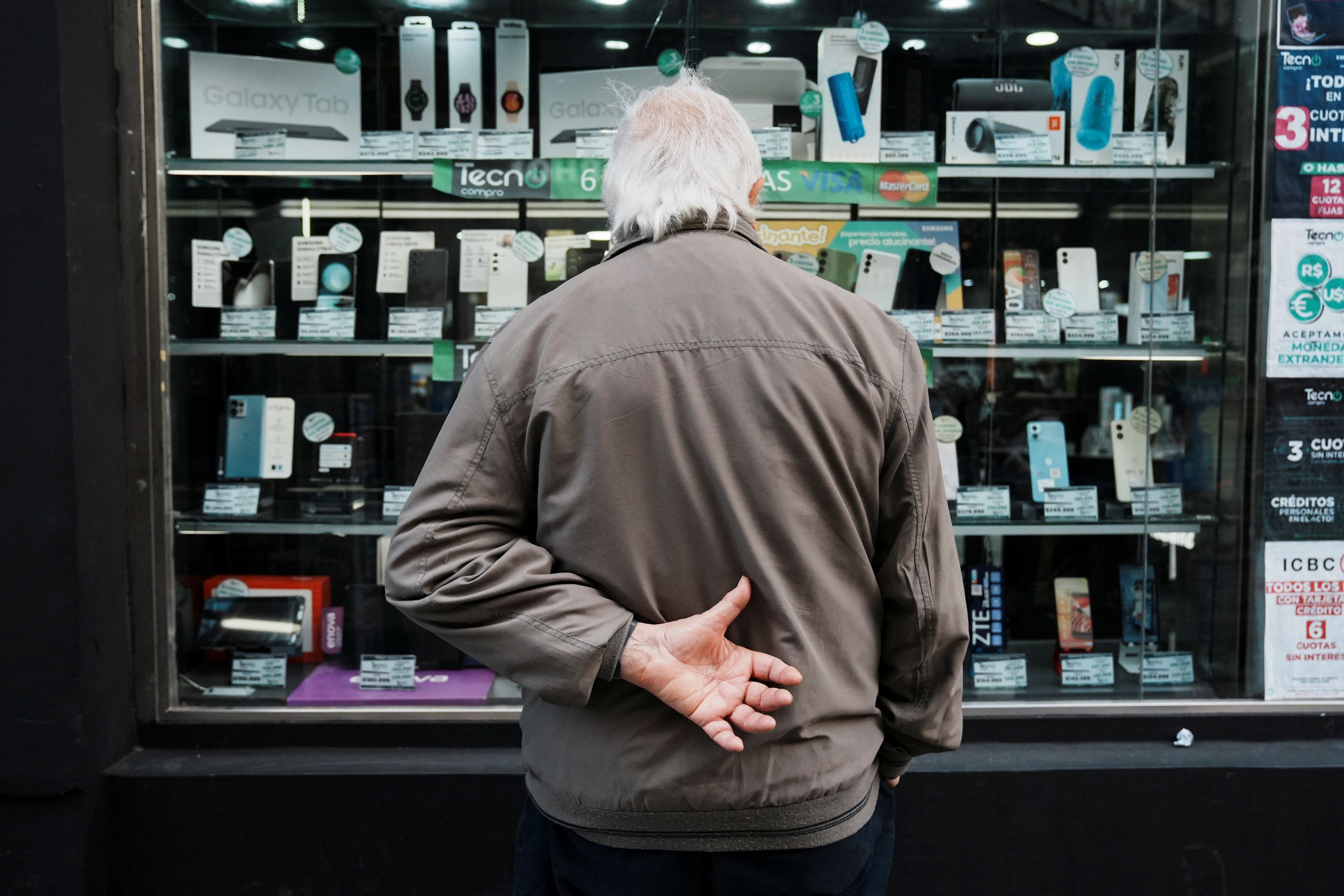 Argentine shoppers peers into an electronics store window