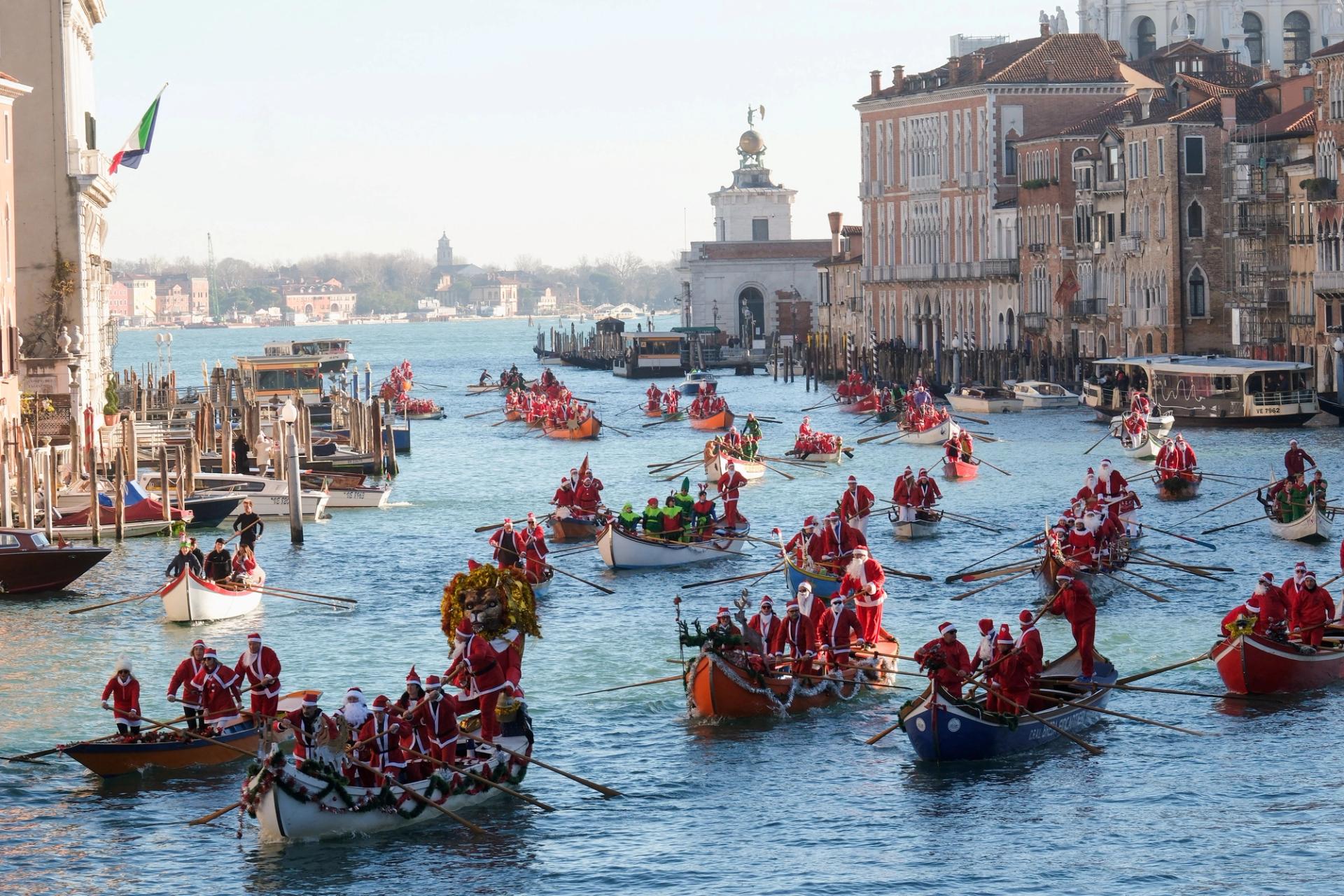 People dressed as Santa Claus row during a Christmas regatta along the Grand Canal in Venice, Italy, December 17, 2023.