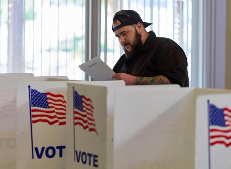 A voter looks at a ballot
