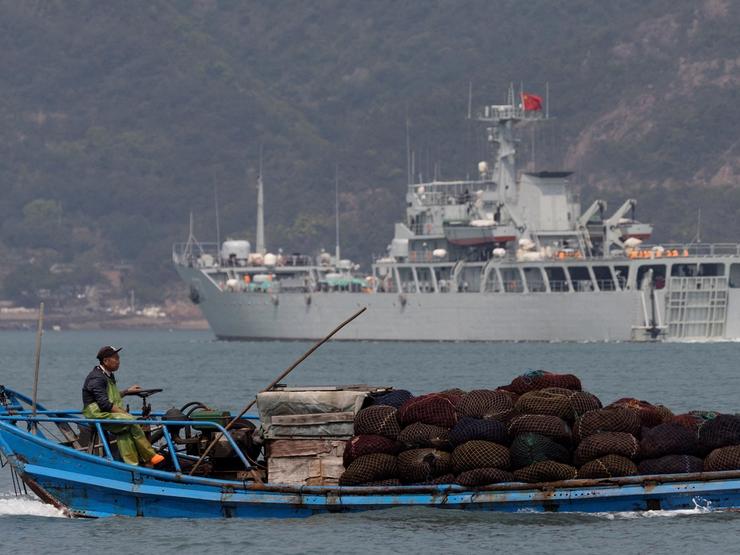 FILE PHOTO: A fishing boat sails past a Chinese warship during a military drill off the Chinese coast near Fuzhou, Fujian Province, across from the Taiwan-controlled Matsu Islands, China, April 11, 2023. REUTERS/Thomas Peter/File Photo