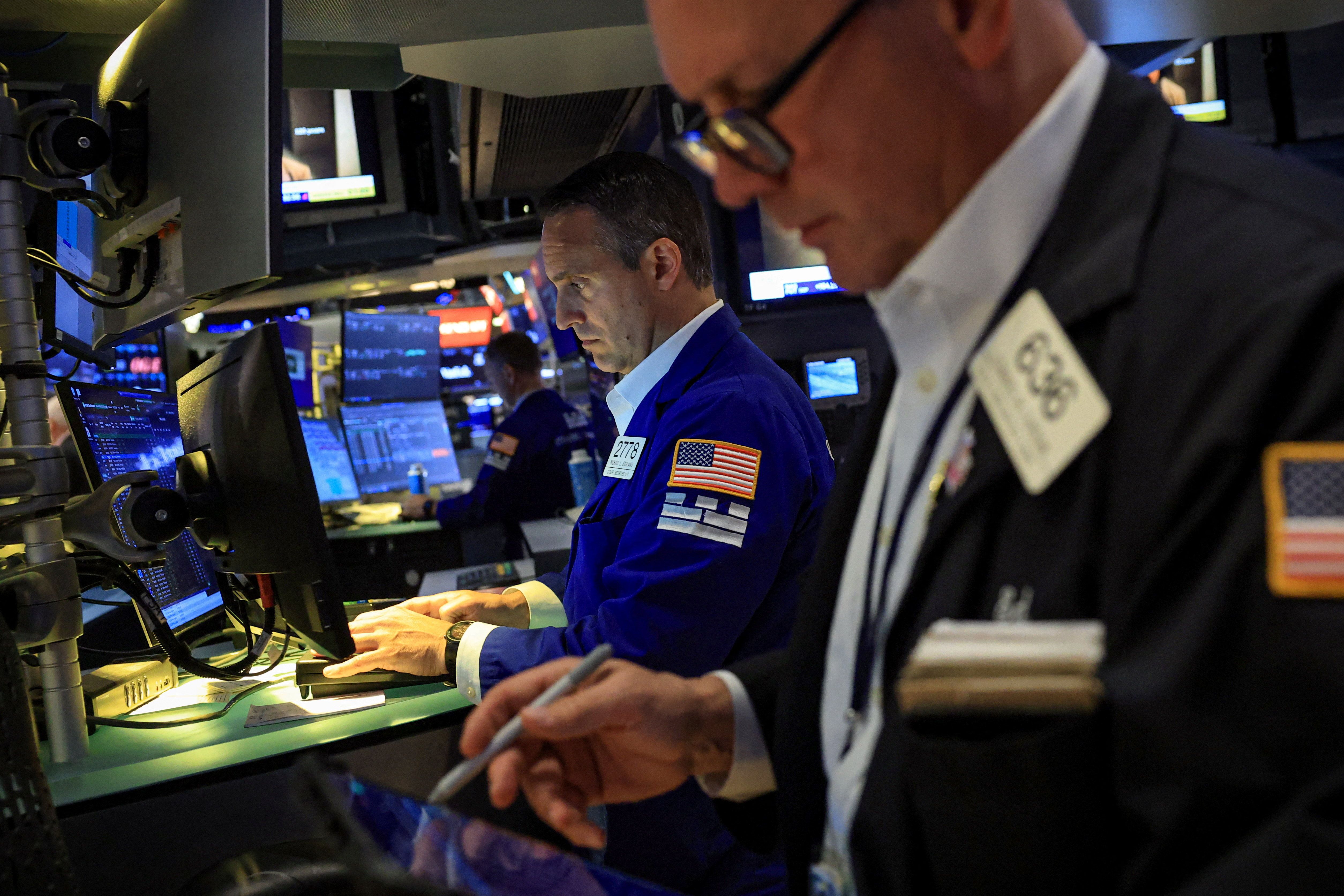 Traders work on the floor at the New York Stock Exchange