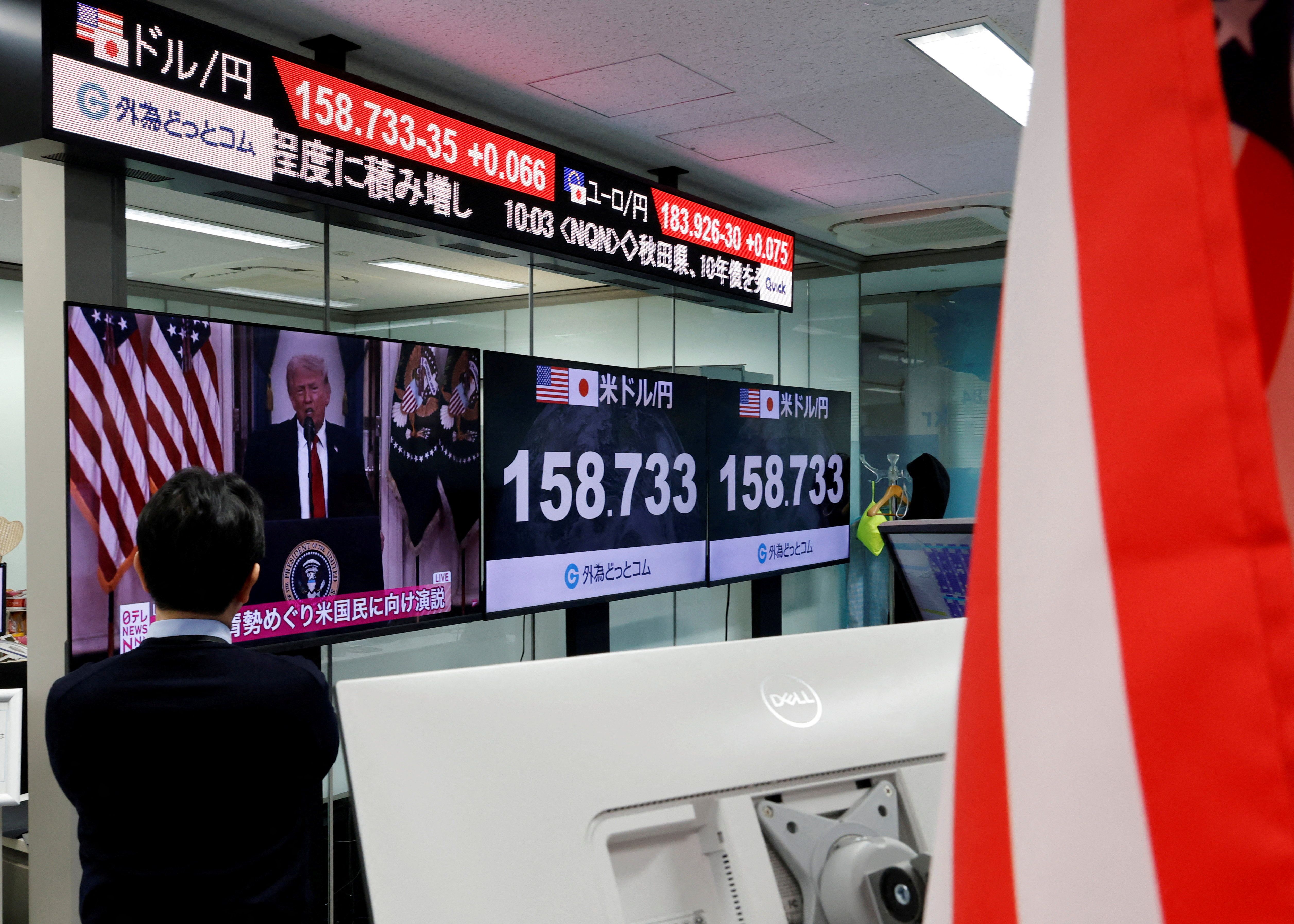 A TV screen broadcasts Trump’s speech about the Iran war at a foreign exchange trading company in Tokyo