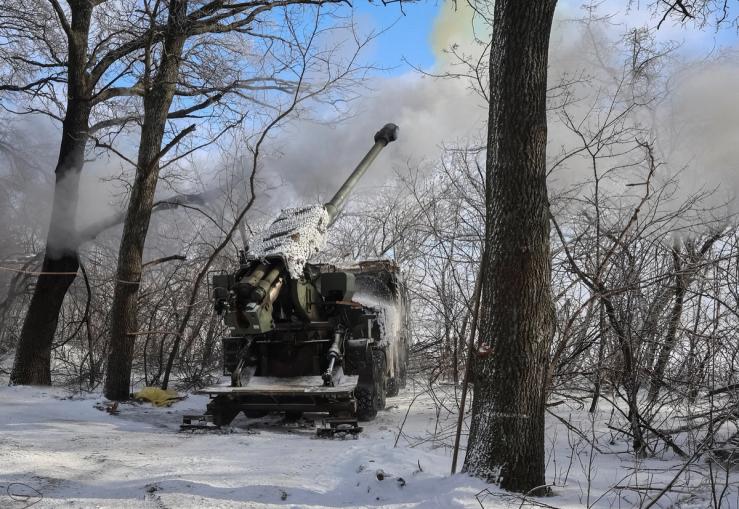 Service members of the 48th Separate Artillery Brigade of the Ukrainian Armed Forces fire a 2S22 Bohdana self-propelled howitzer towards Russian troops near a front line.