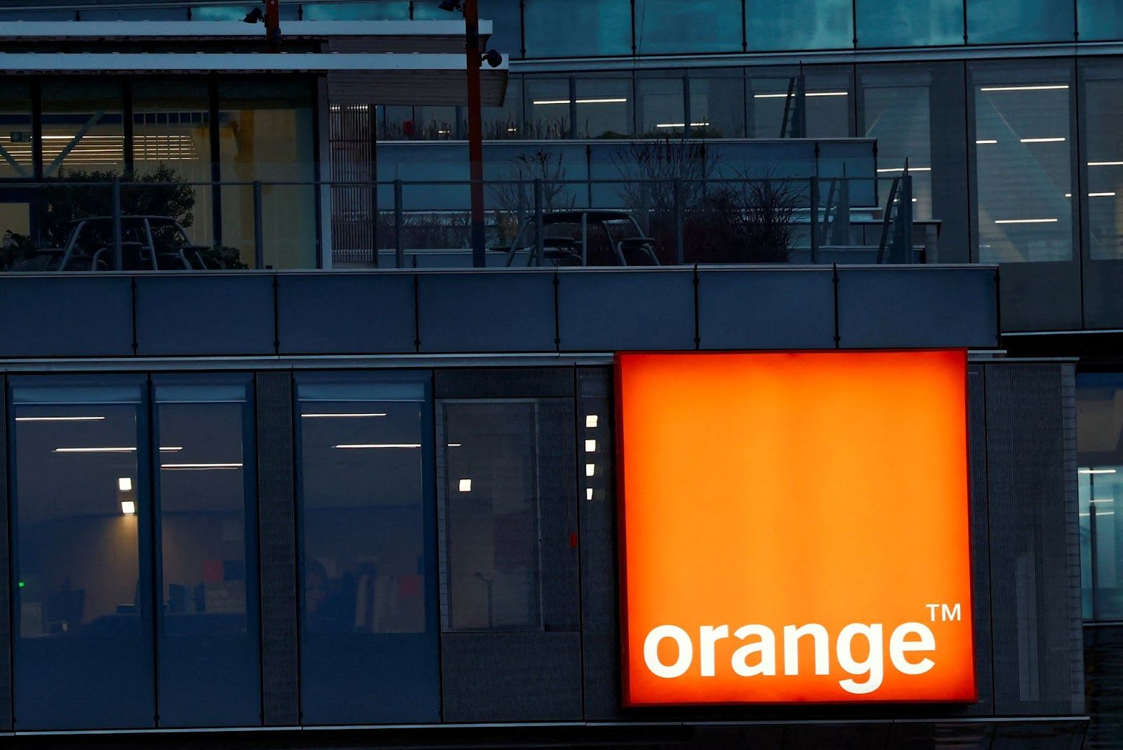 Logo of French telecom operator Orange hangs at the company headquarters near Paris. 