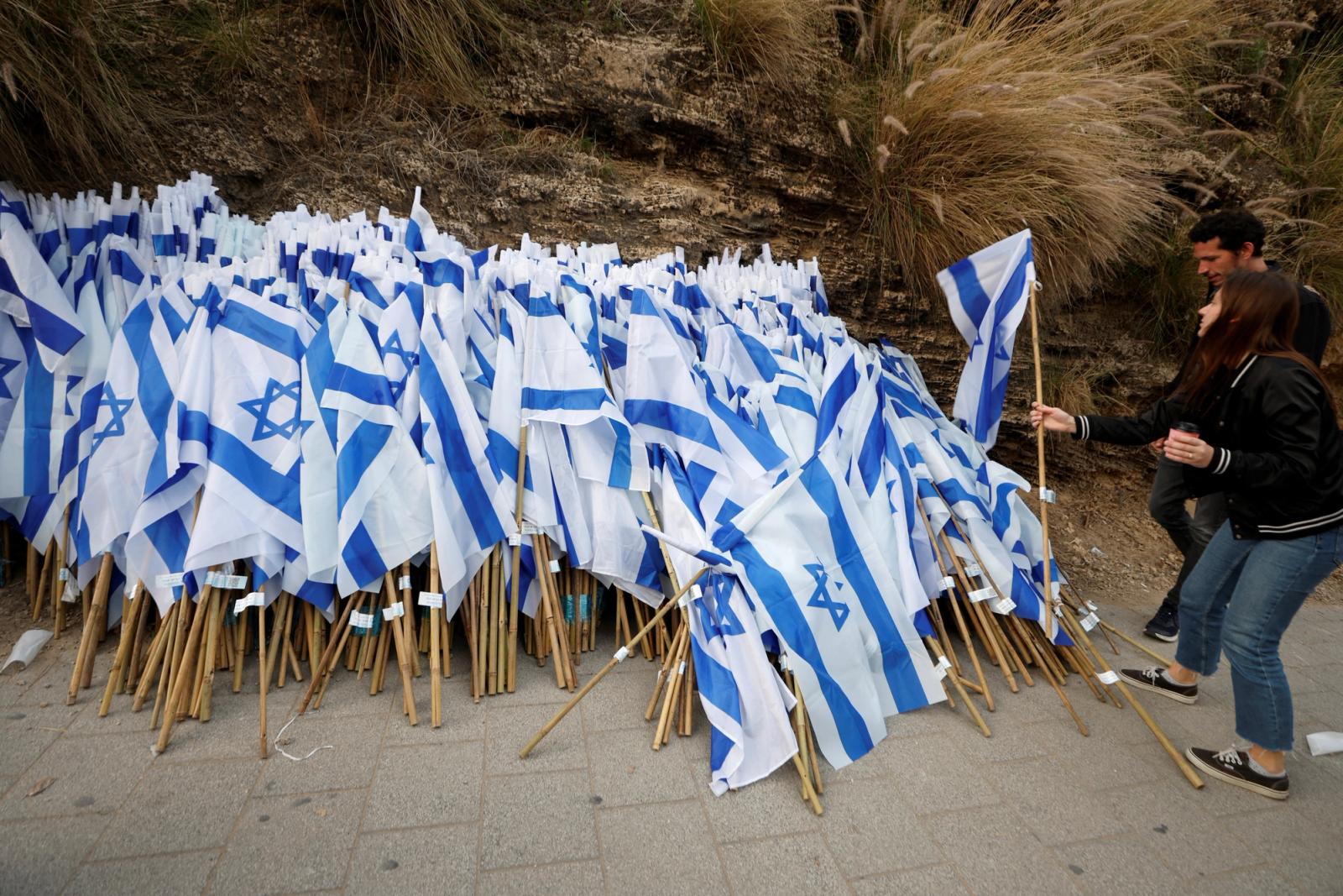 People take Israeli flags as they attend a demonstration, as Israeli Prime Minister Benjamin Netanyahu's nationalist coalition government presses on with its judicial overhaul, in Tel Aviv, Israel March 25, 2023. REUTERS/Amir Cohen