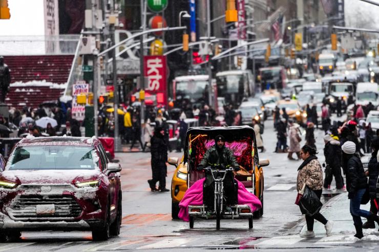 People make their way during a snowfall at Times Square.