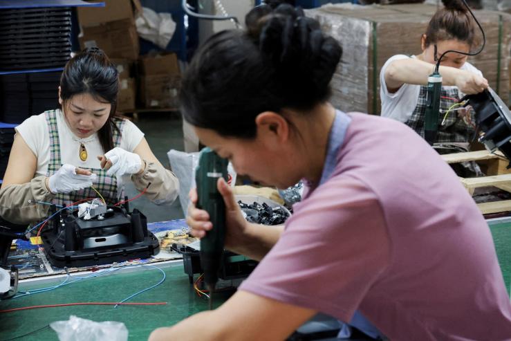 Employees of Gstar Electronic Appliance Co., Ltd work to assemble air fryers.