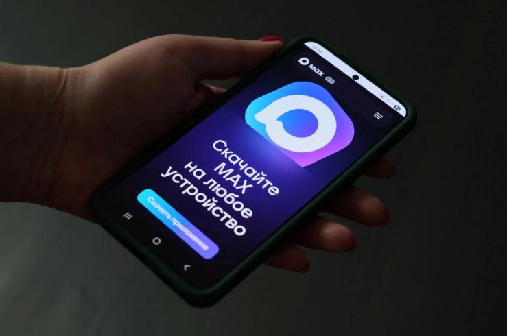 A hand holding a phone displaying Russia’s MAX app