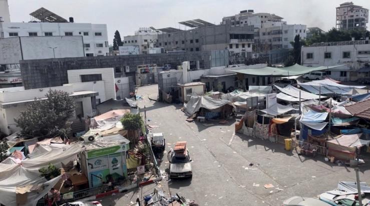 Displaced Palestinians shelter in tents at the yard outside Al-Shifa while Israeli forces invade the hospital.