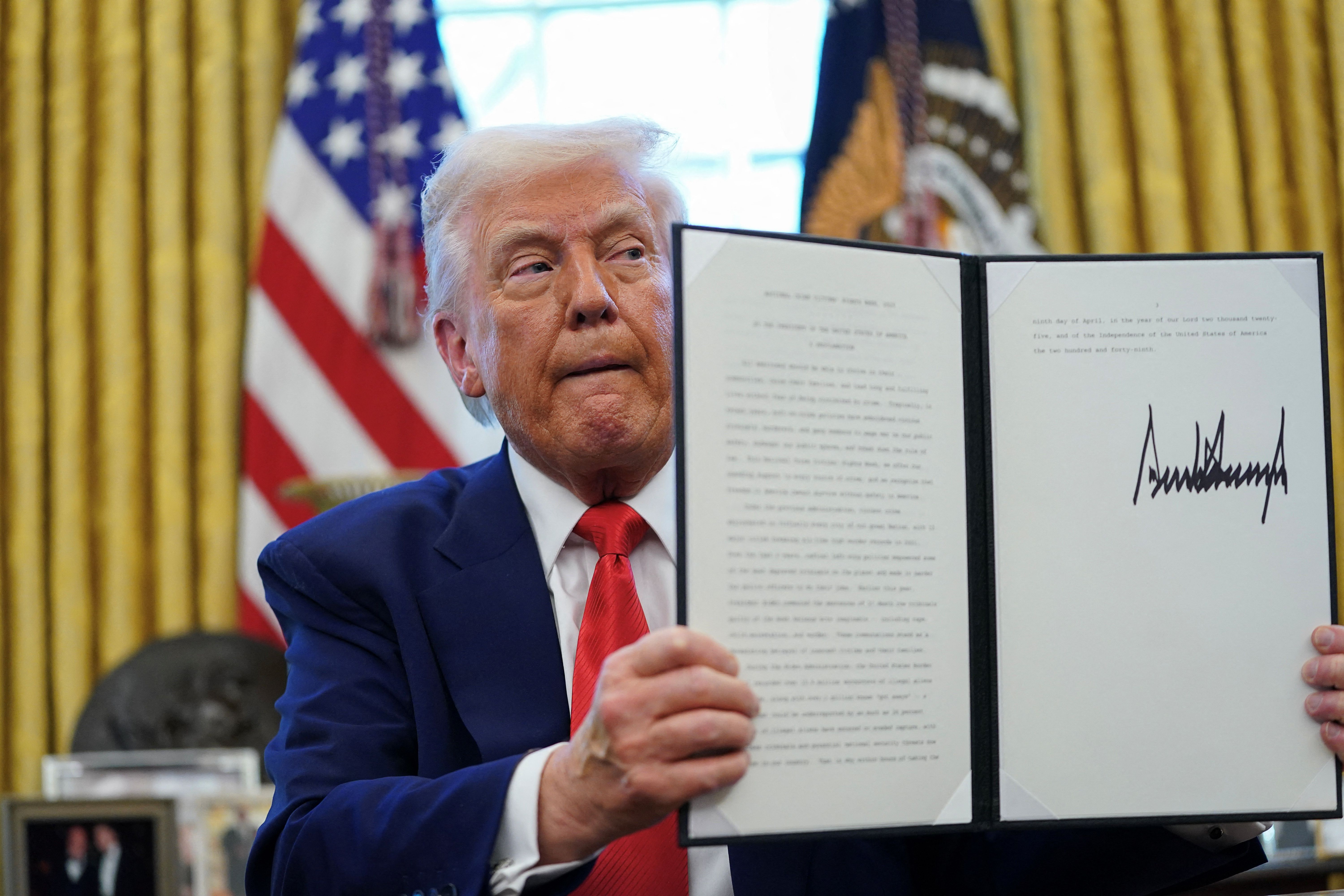 U.S. President Donald Trump looks on, as he signs executive orders and proclamations in the Oval Office.