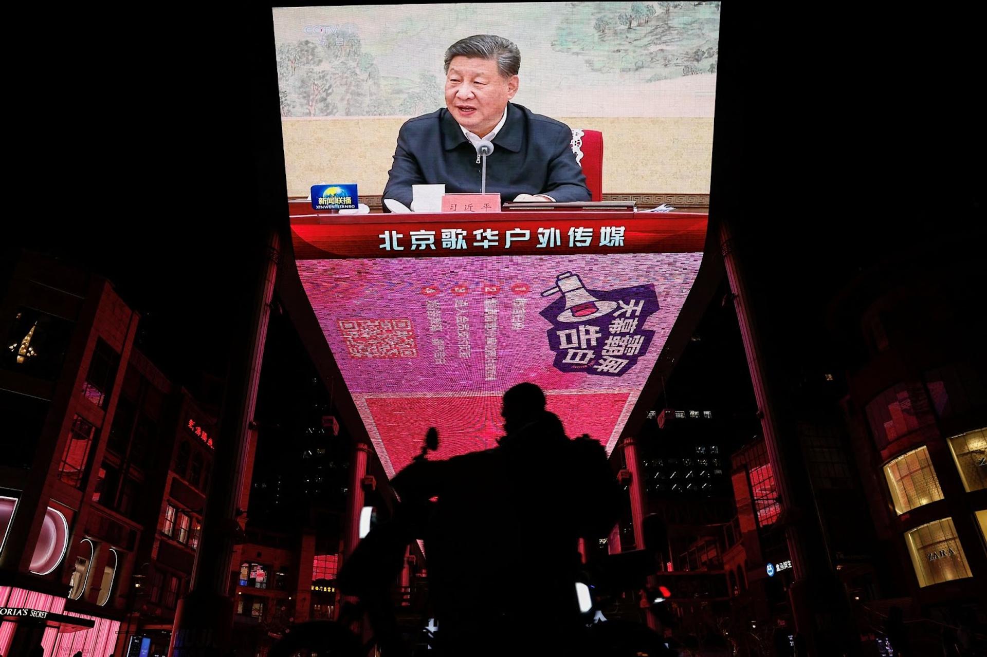 A giant screen in Beijing shows Xi Jinping attending a Politboro meeting 