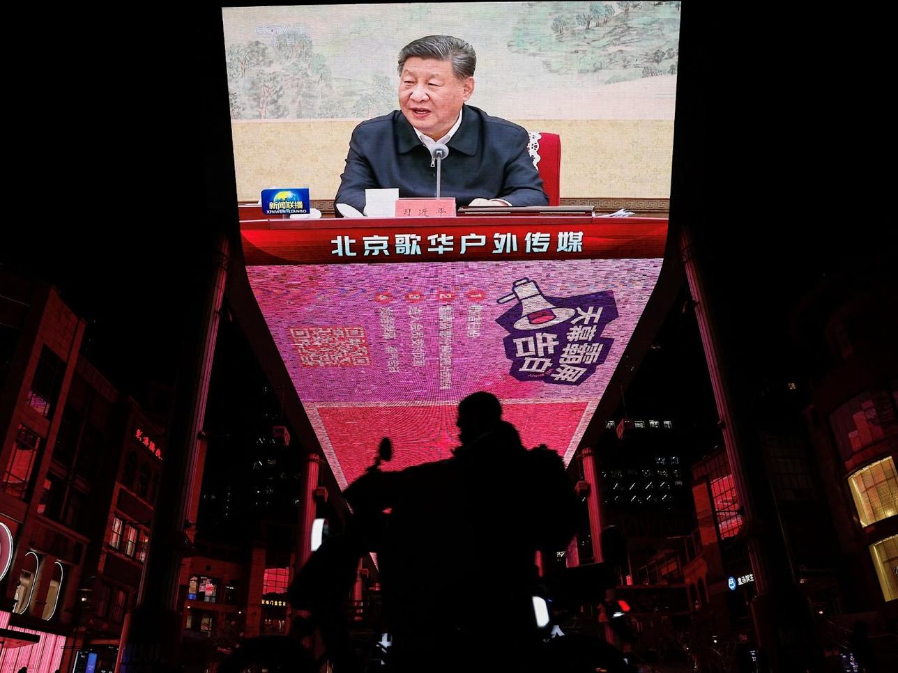 A giant screen in Beijing shows Xi Jinping attending a Politboro meeting