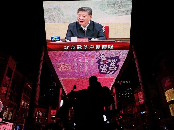 A giant screen in Beijing shows Xi Jinping attending a Politboro meeting