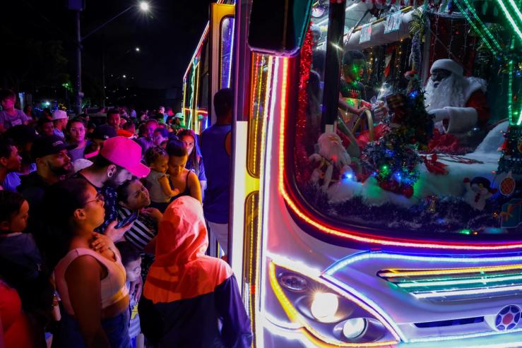 Councilman Edilson Santos, dressed as Santa Claus, drives the ‘Bus Noel’, a bus decorated by him and his family with Christmas ornaments, as people wait to board it at Jardim Alzira Franco, in Santo Andre, Brazil December 19, 2023.