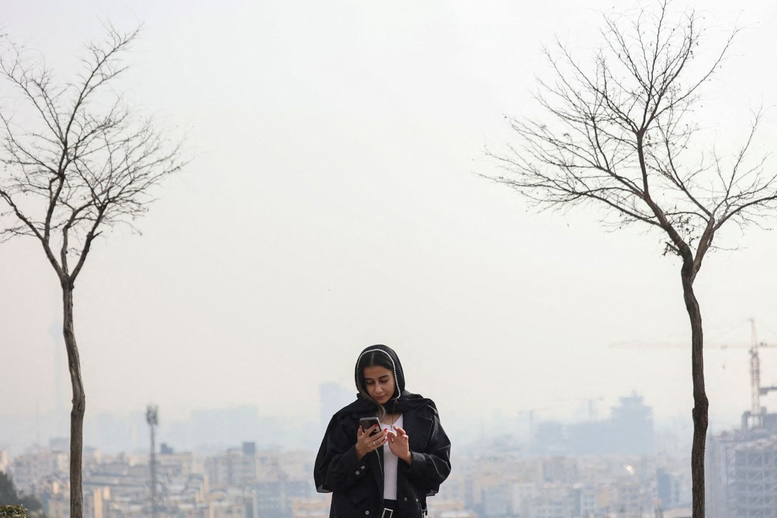 An Iranian woman looking at her mobile phone. 