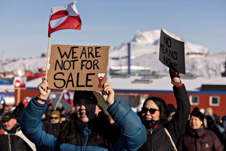 Demonstrators in Greenland holding a sign reading “We are not for sale.”