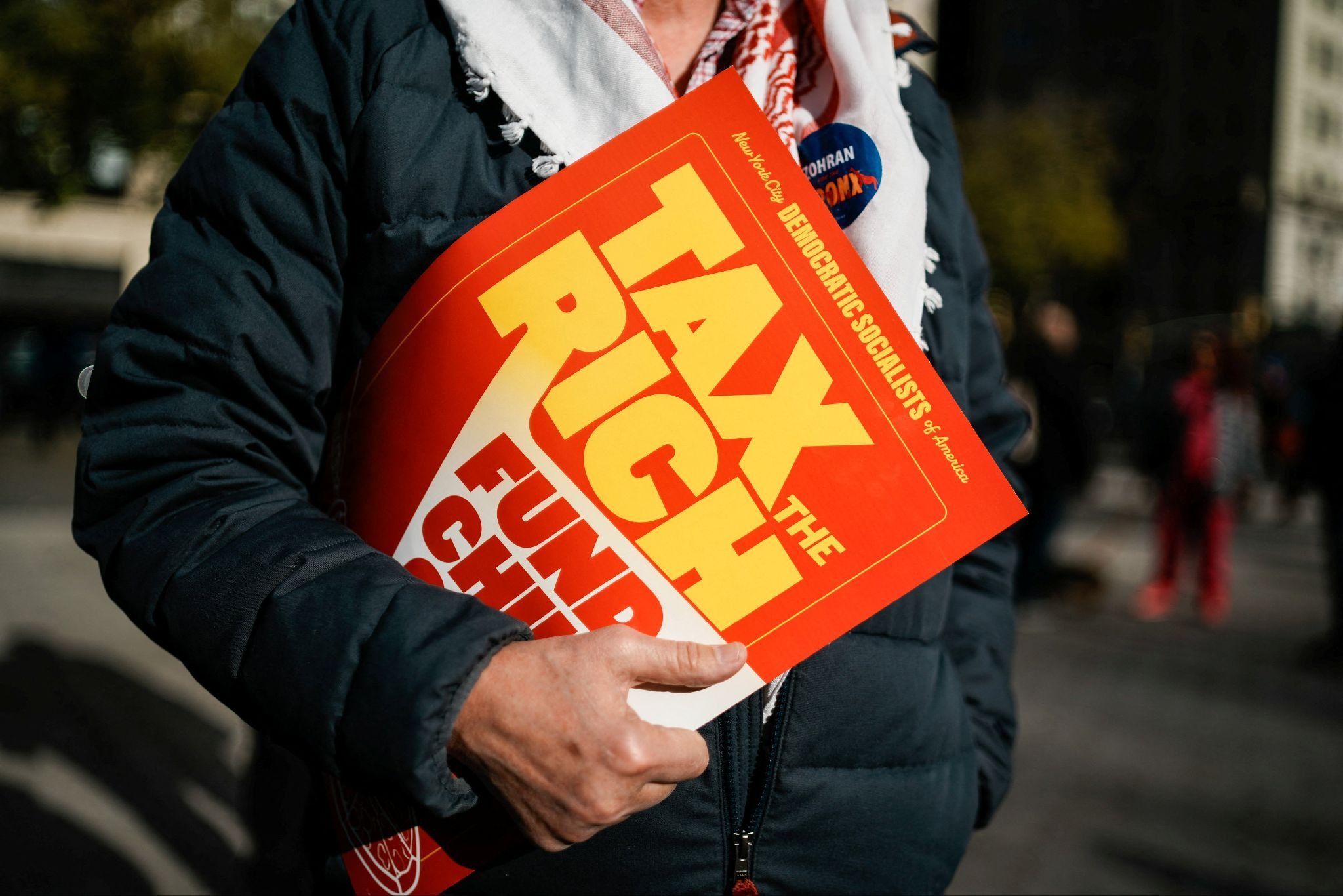 Protester with “Tax the Rich” placard
