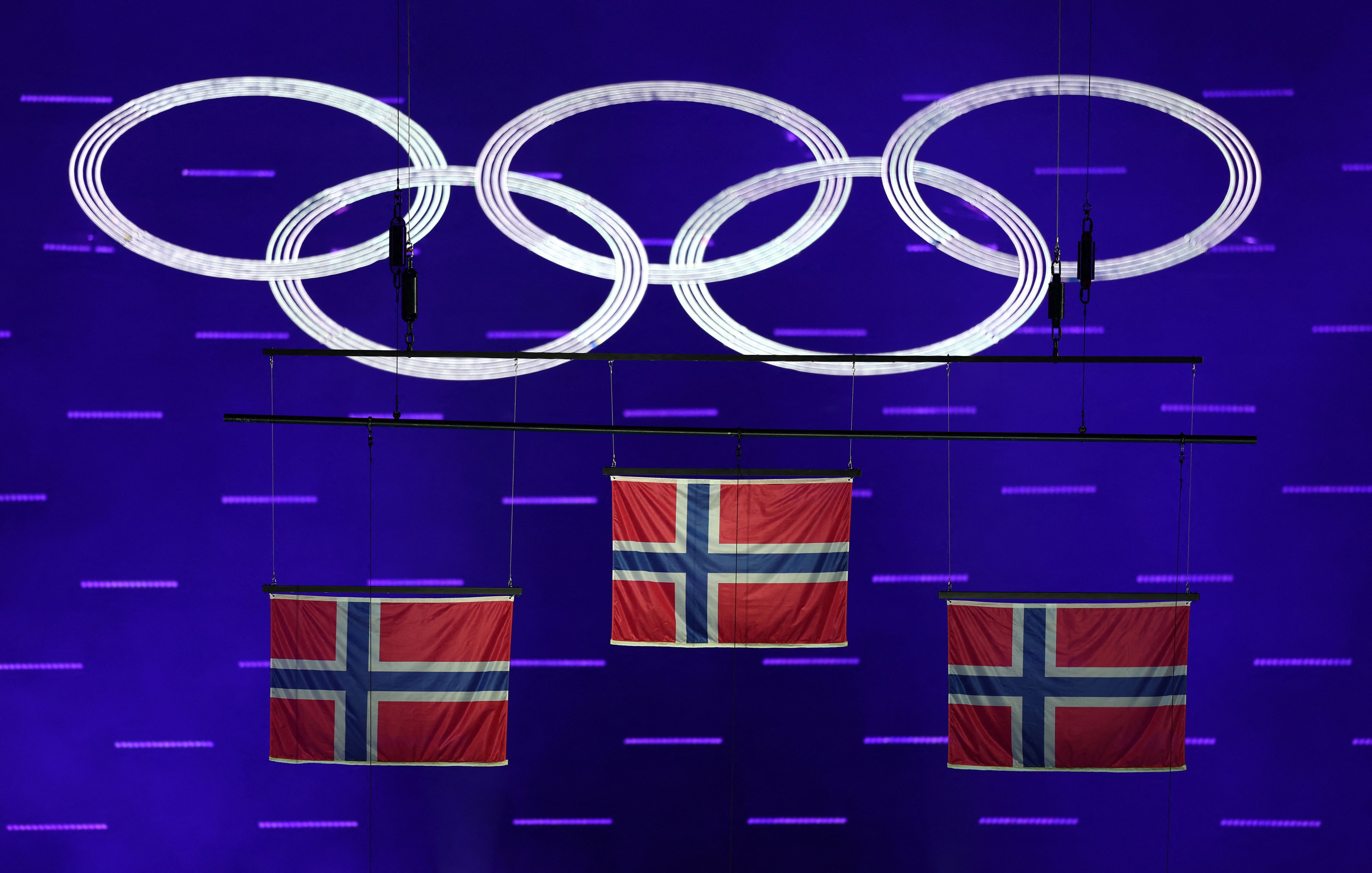 The national flags of gold medallist Johannes Hosflot Klaebo of Norway, silver medallists Martin Lowstrom Nyenget of Norway and bronze medallist Emil Iversen of Norway are raised during the Men’s 50km Mass Start Classic Victory Ceremony.