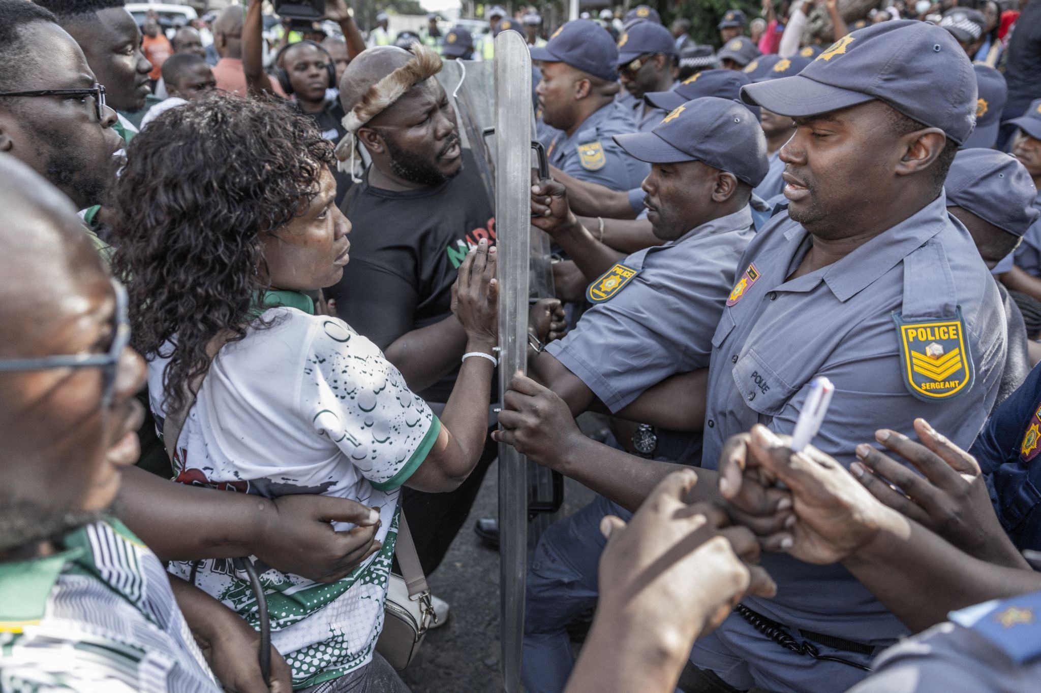 Members of “March and March” migrant protest are confronted by members of the South African Police Service.