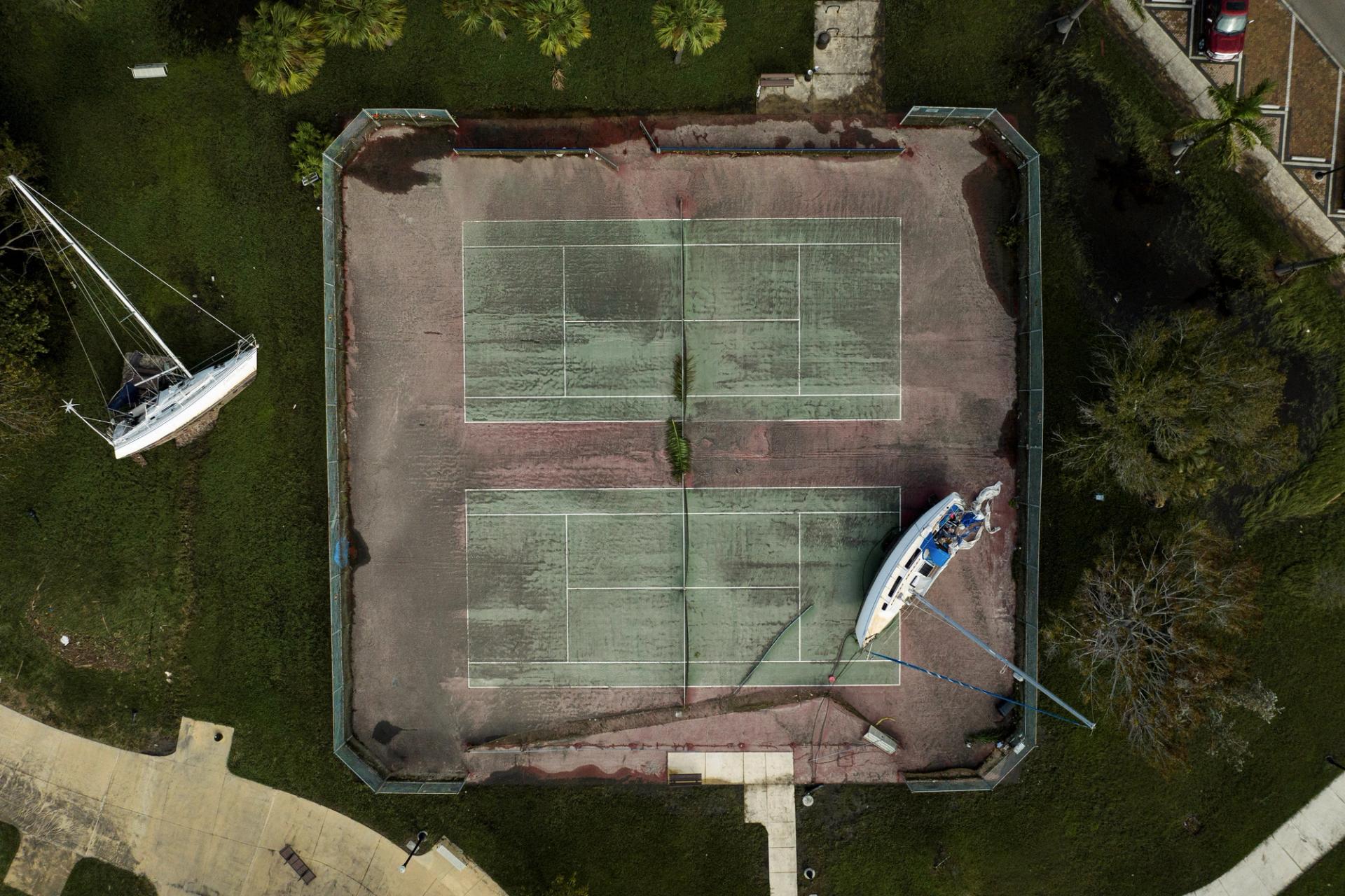 Hurricane Milton aftermath shows a yacht washed up on a tennis court in Florida.