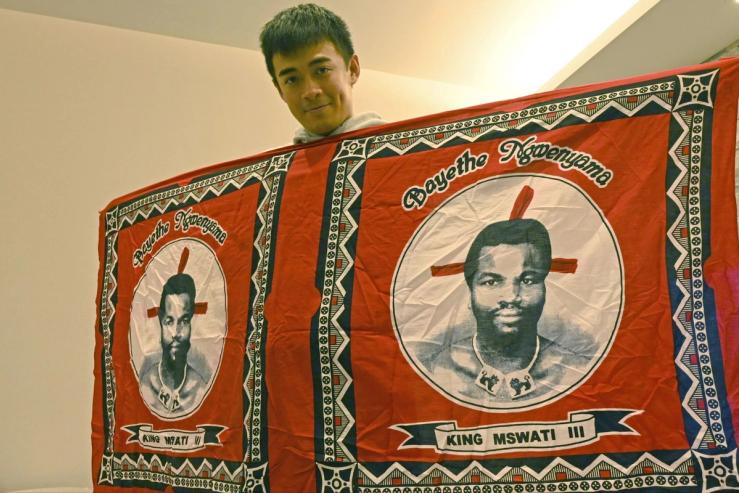 A Taiwanese activist holds a flag displaying the face of King Mswati III of Eswatini, Taiwan’s only diplomatic ally on the continent.