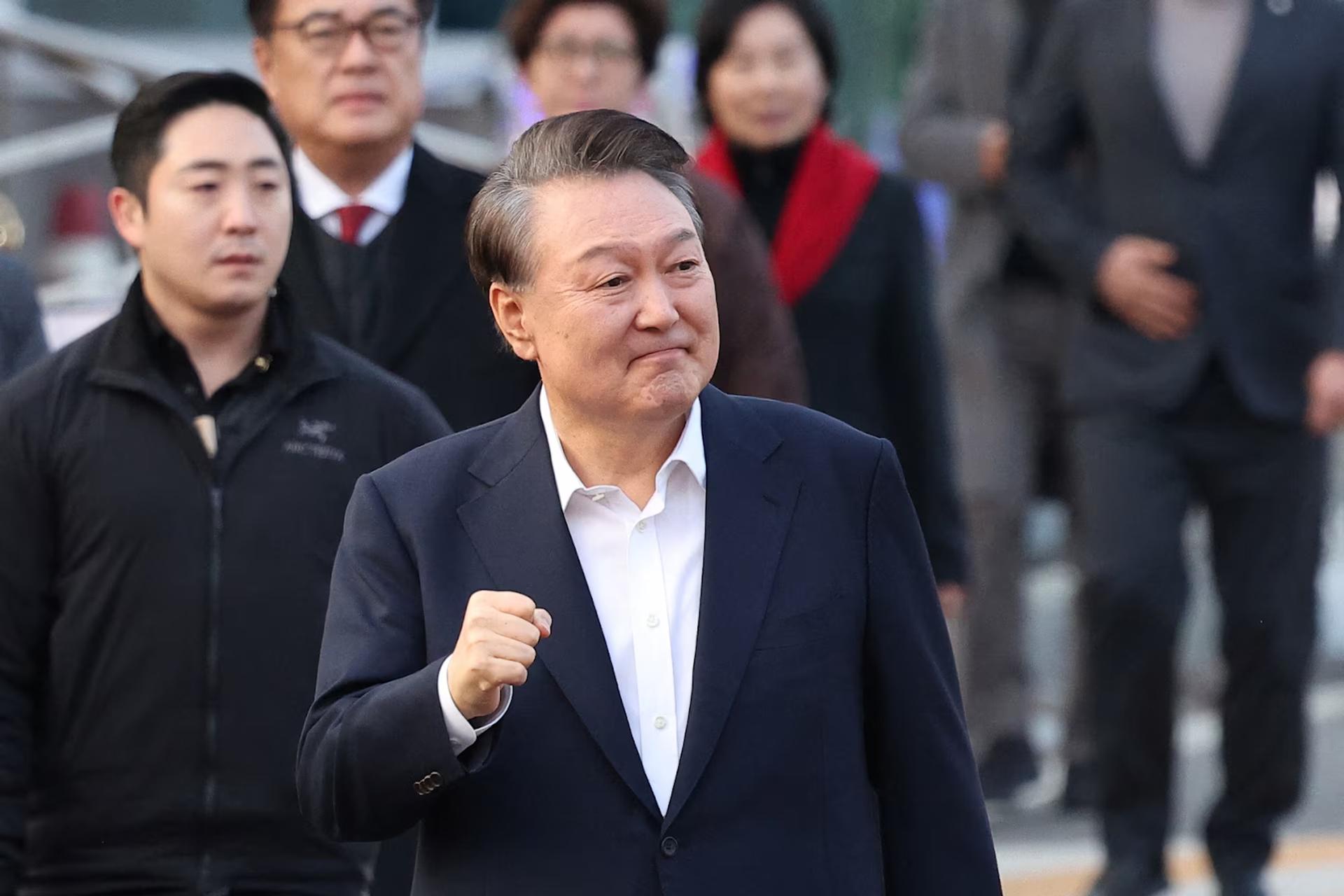 South Korean impeached President Yoon Suk Yeol gestures outside the Seoul detention center after his release.