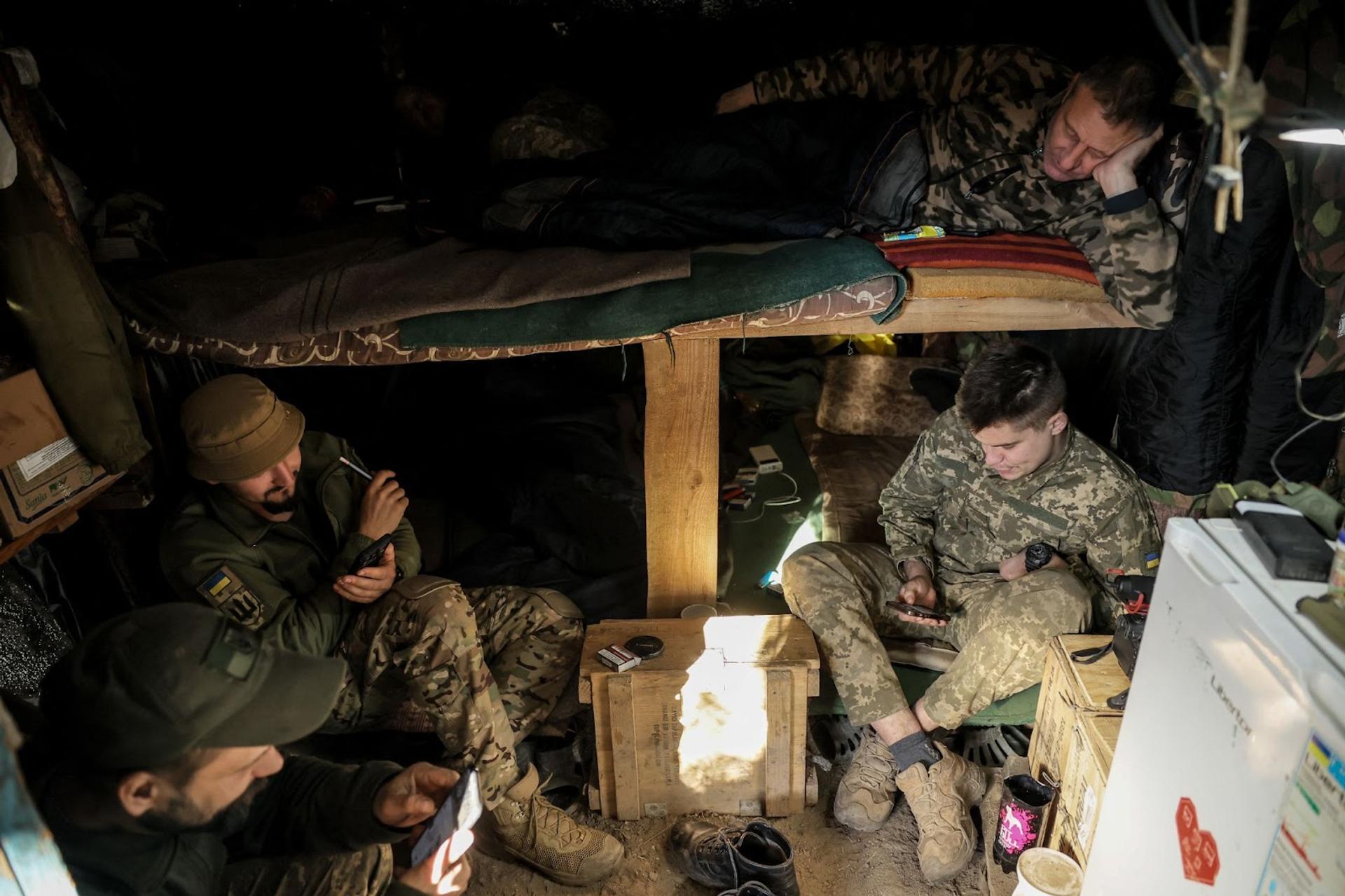 Members of the Ukrainian Armed Forces rest in a dugout near the frontline 