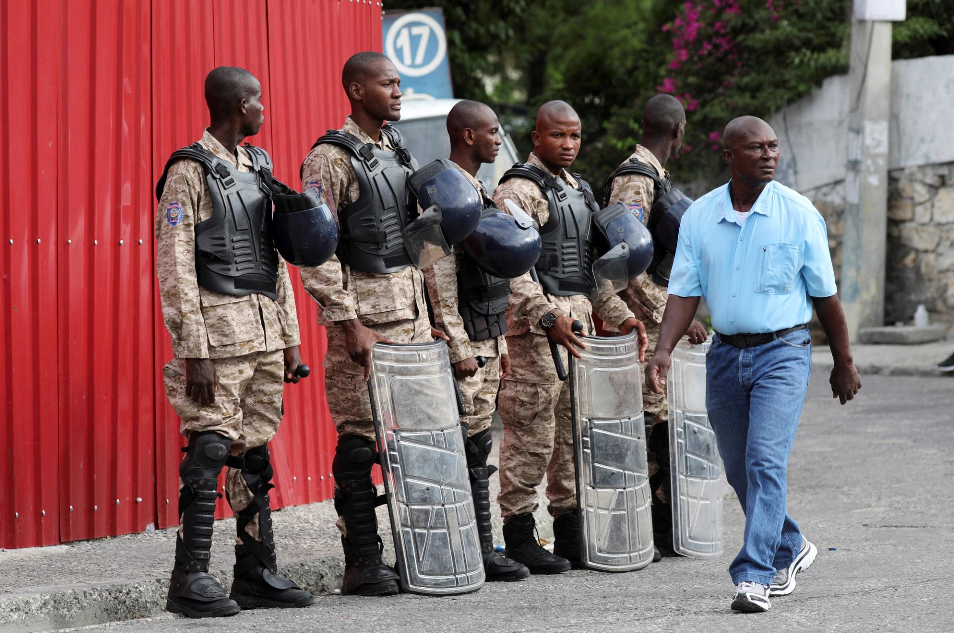 Police officers stand guard before a Ceremony to install Transition Council, on the outskirts of Port-au-Prince, Haiti.  