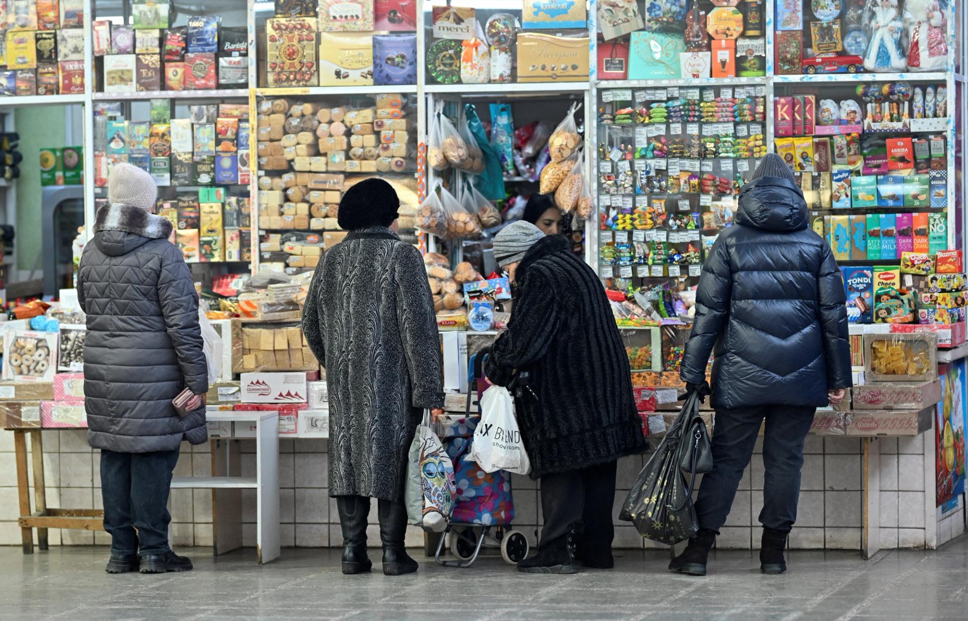 Customers wait in line outside a kiosk at a food market in the Siberian city of Omsk, Russia.