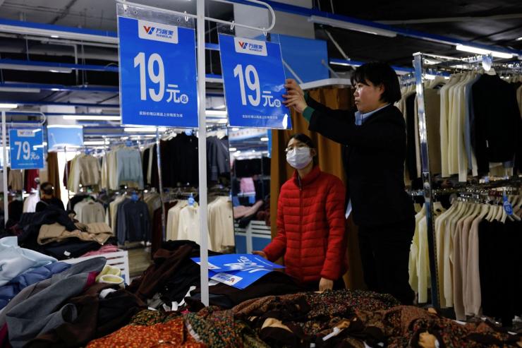 A department store employee changes price signs