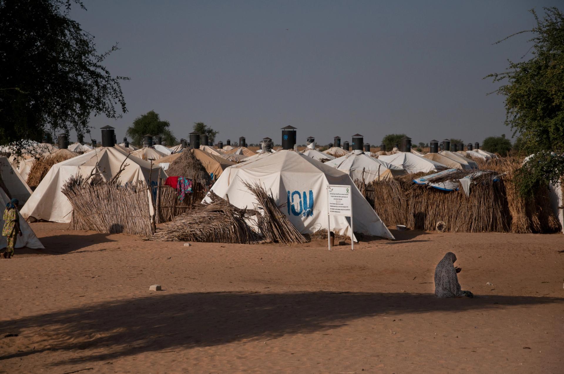 A woman prays in front of a camp for people displaced by the conflict against Boko Haram.