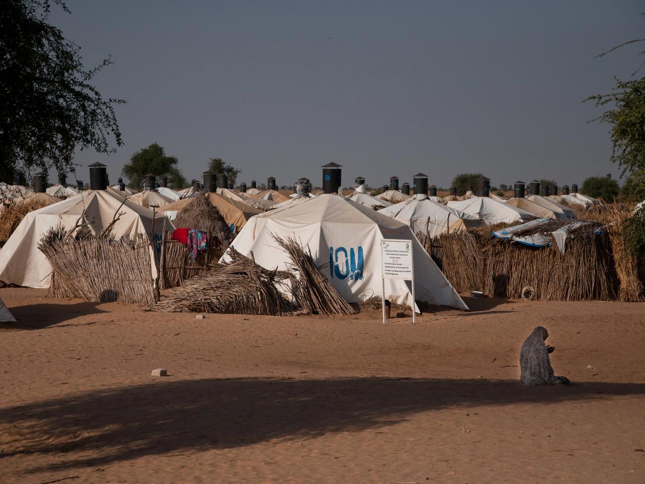 A woman prays in front of a camp for people displaced by the conflict against Boko Haram.