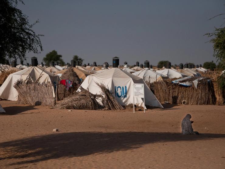 A woman prays in front of a camp for people displaced by the conflict against Boko Haram.