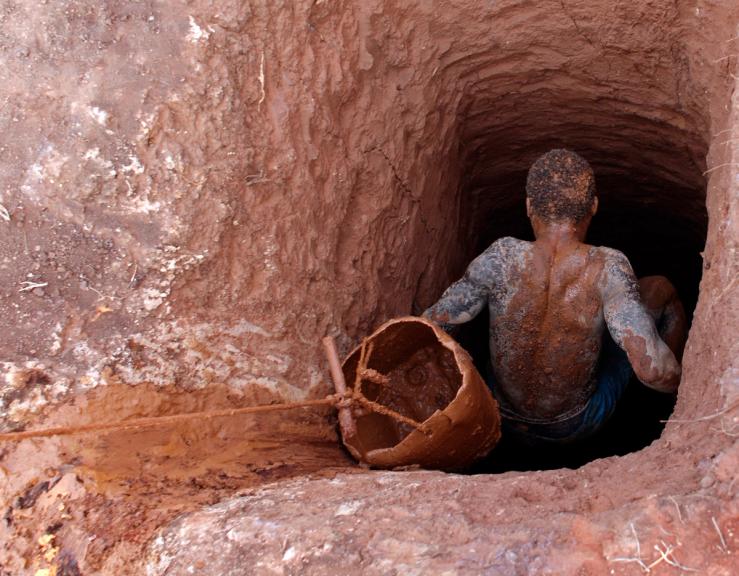 A gold miner climbs down into a mine shaft in Manica Province, Mozambique.