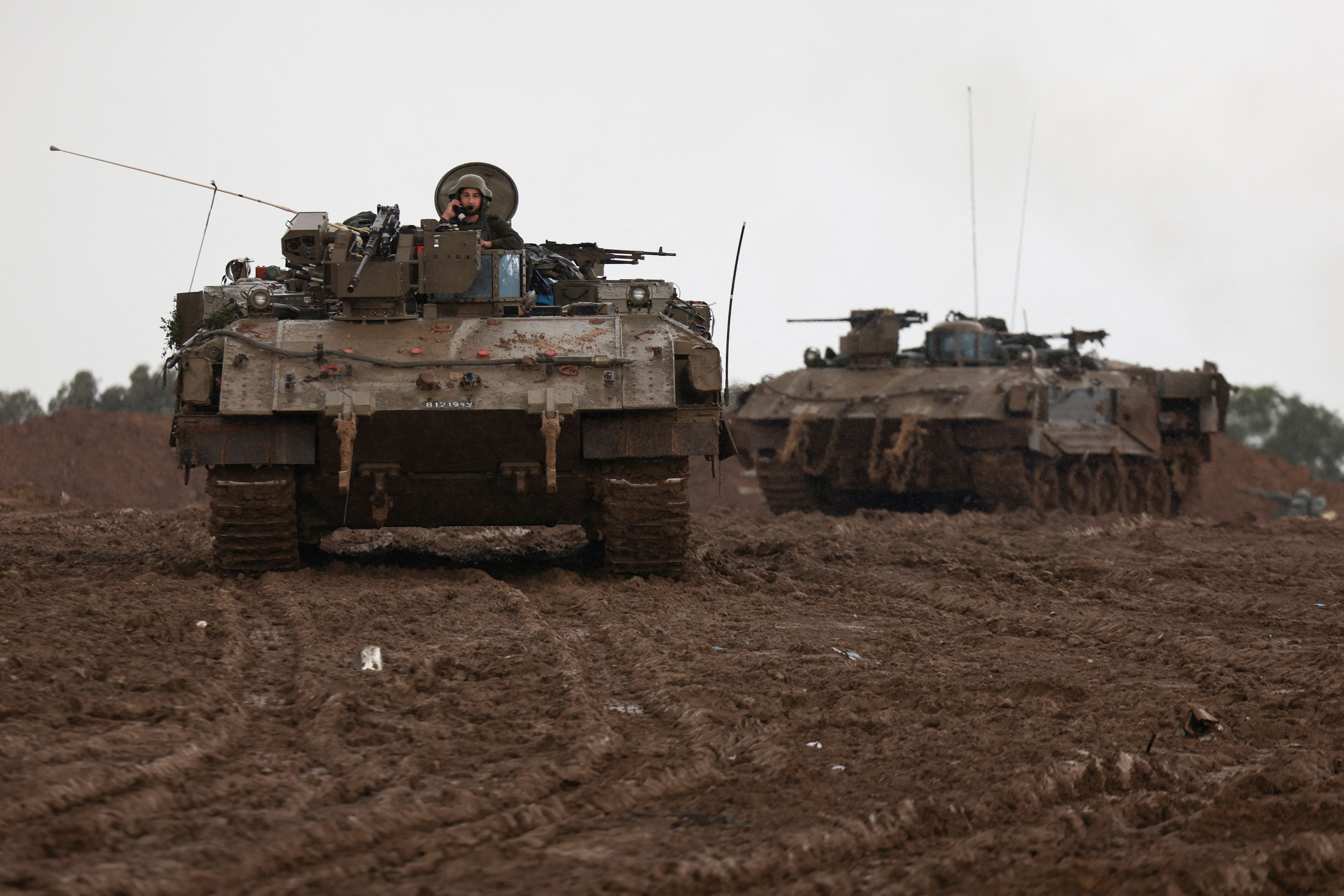 Israeli armored personnel carriers maneuver at Israel’s border with Gaza in southern Israel, December 13, 2023.