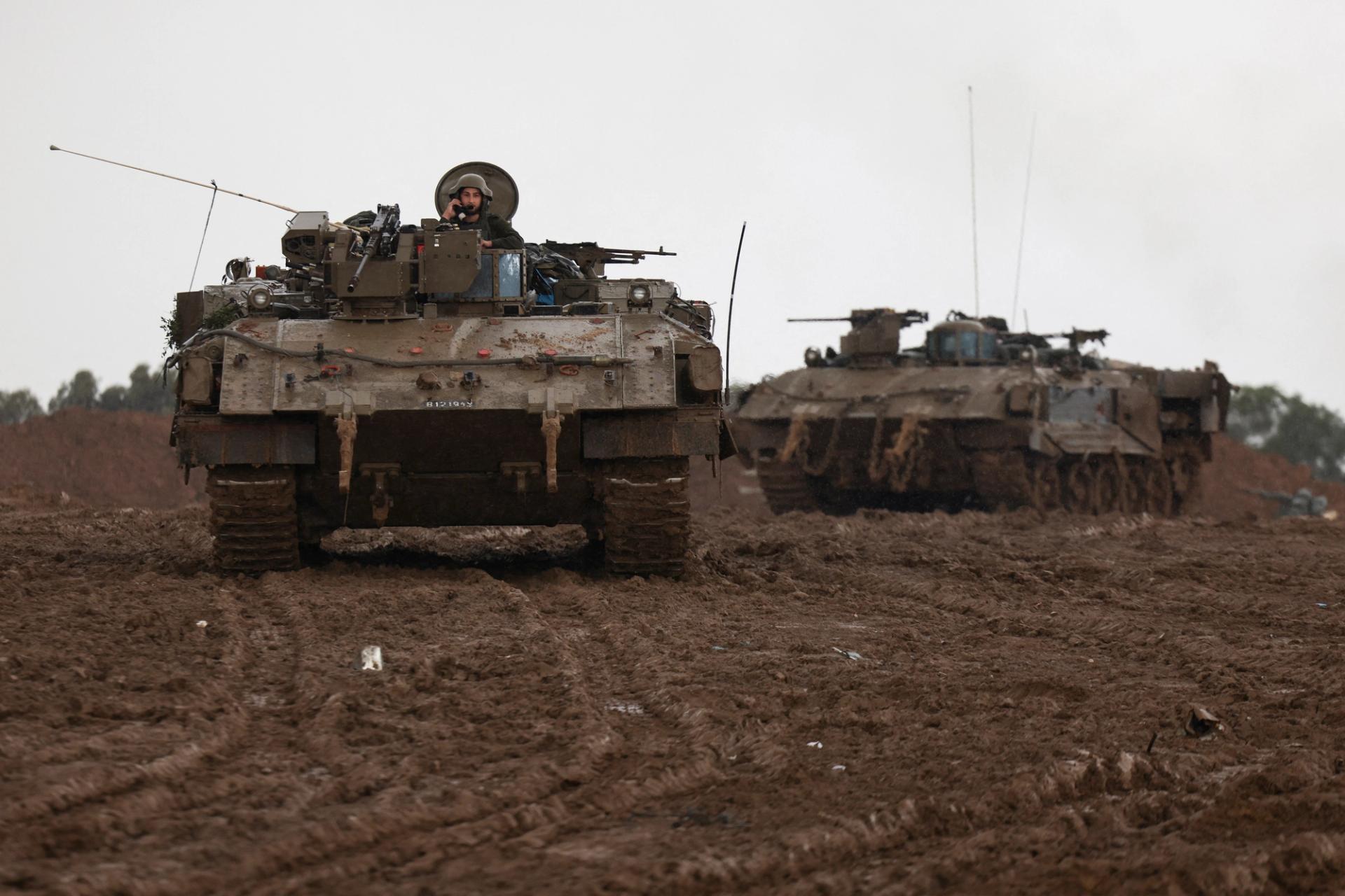 Israeli armored personnel carriers maneuver at Israel's border with Gaza in southern Israel, December 13, 2023.