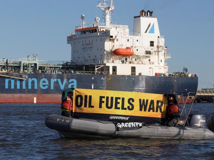 Greenpeace activists protesting near an oil tanker.